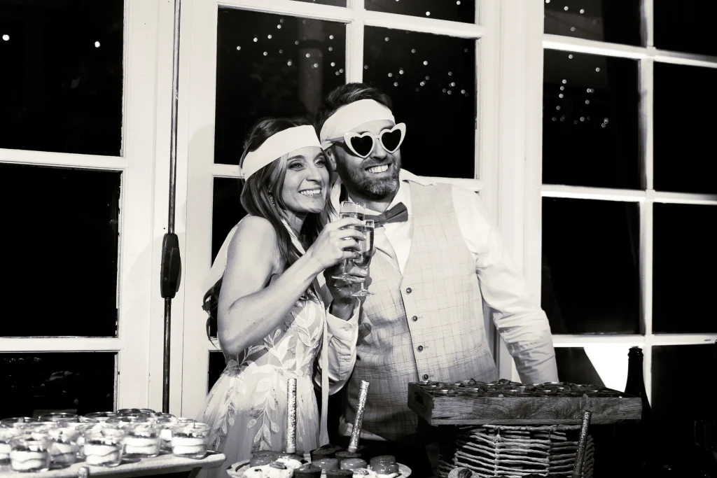Photographe de mariage Lille, couple dans la salle de réception qui trinque à leur weeding cake (Gâteau)